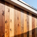 Detailní pohled na moderní dřevěný obklad domu s různými texturami a barvami za denního světla